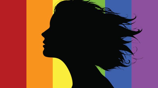 Woman's profile in front of a rainbow flag