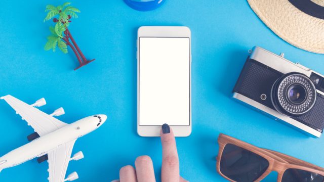 Smartphone surrounded by travel objects