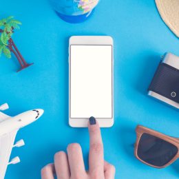 Smartphone surrounded by travel objects
