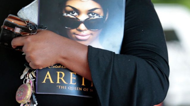 A woman holds a program from Aretha Franklin's funeral