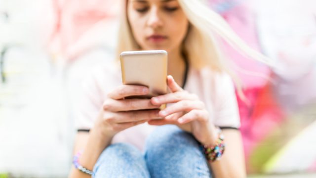 Teenage girl texting on smartphone