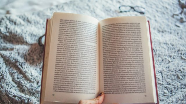 Women's hand holding open book