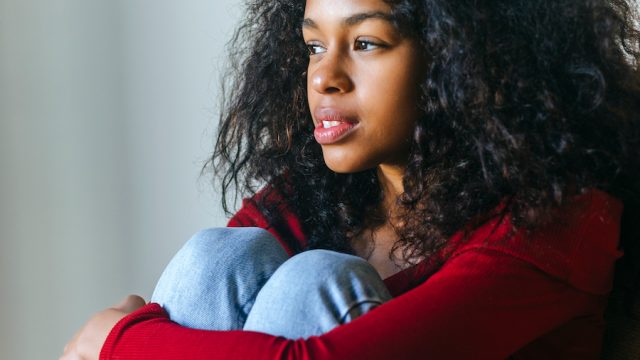 Woman sitting with her knees to chest