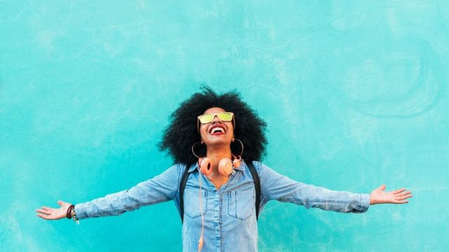 Woman smiling in front of blue well