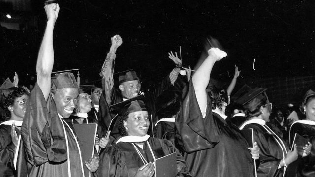 Black students giving the Black Power salute at a college graduation