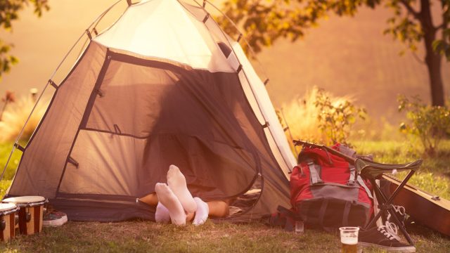 Young couple having safe sex in tent