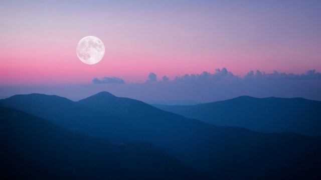 Full moon rising over the mountain range in Carpathians
