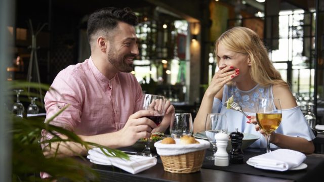 guy and girl flirt at restaurant on date