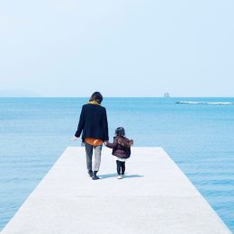 Mother and child holding hands on pier