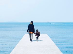 Mother and child holding hands on pier