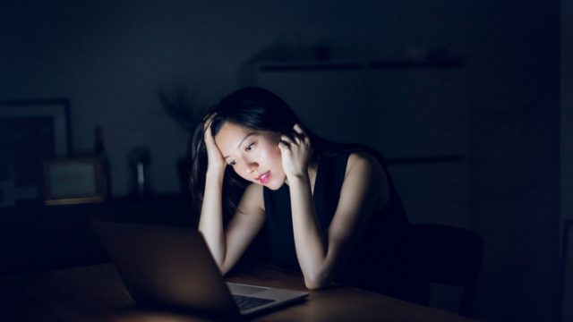 Stressed woman looking at laptop