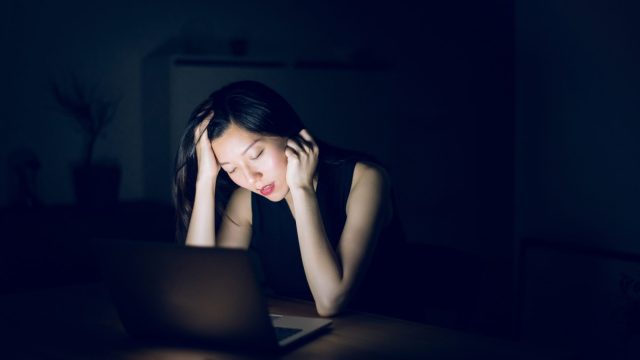 Picture of tired woman working in front of a laptop