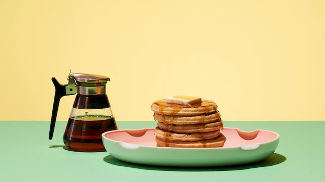 Pancakes and syrup on a yellow and green background