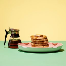 Pancakes and syrup on a yellow and green background