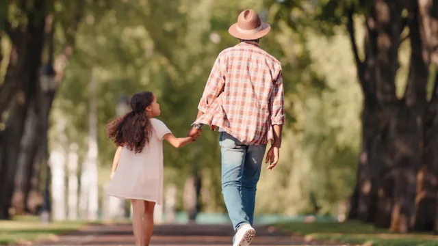Grandfather and granddaughter walking along a path