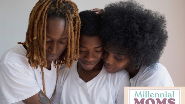 Two moms hugging child