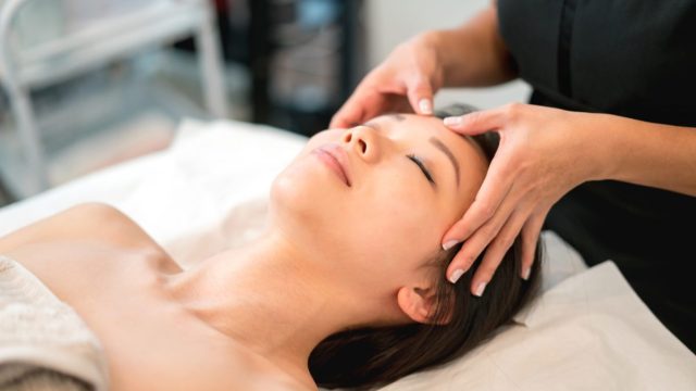 Asian woman getting a face massage at the spa