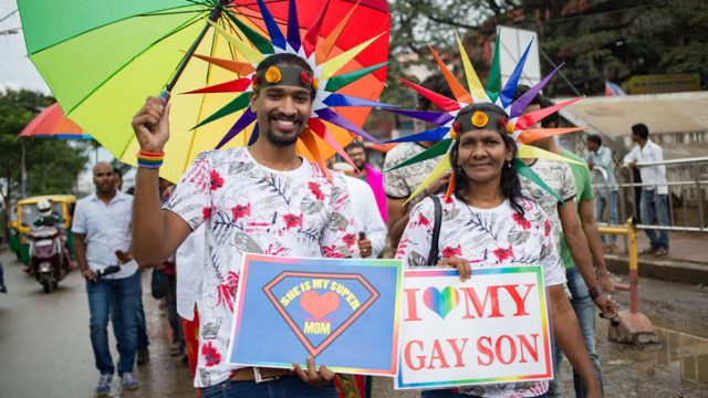 Mother and son at Pride parade. Mom is holding sign that says, 'I love my gay son'