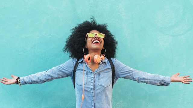 black woman with natural hair wearing headphones and sunglasses