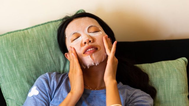 Woman applying face mask