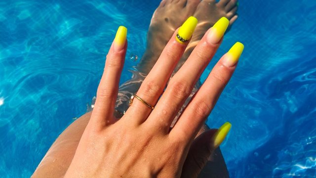 neon ombre nails in gel manicure woman in pool