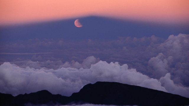 Lunar eclipse at sunset with a moonrise from the summit of Mt Haleakala