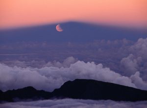Lunar eclipse at sunset with a moonrise from the summit of Mt Haleakala