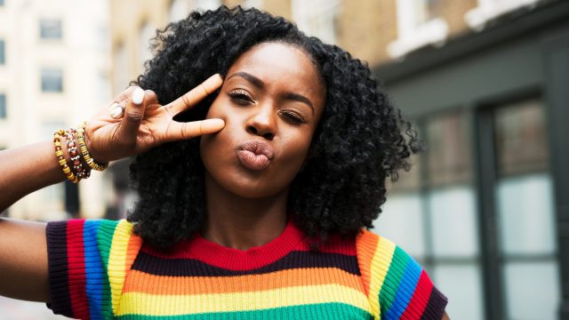 Woman making a kiss face and posing with a peace sign
