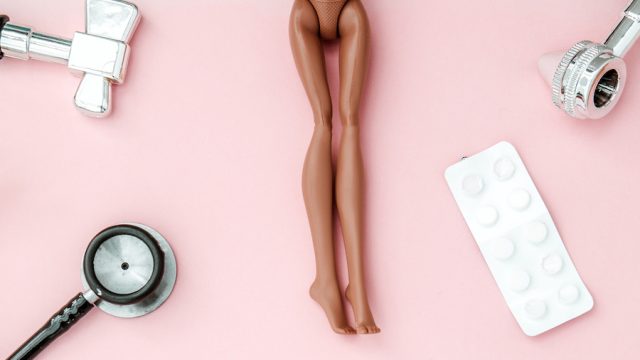 Doll legs surrounded by sexual health objects