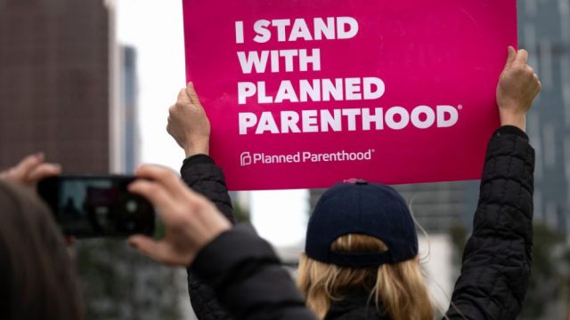 A protester holds a sign that says "I stand with Planned Parenthood."