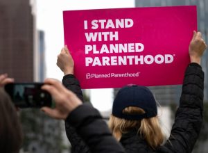 A protester holds a sign that says "I stand with Planned Parenthood."