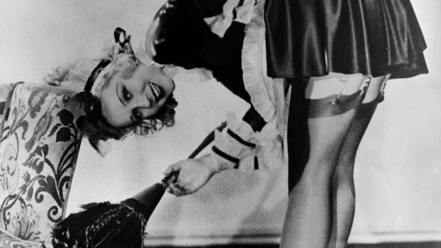 Actress Adrienne Dore bent over in a black and white pin up girl photo from the 40s or 50s