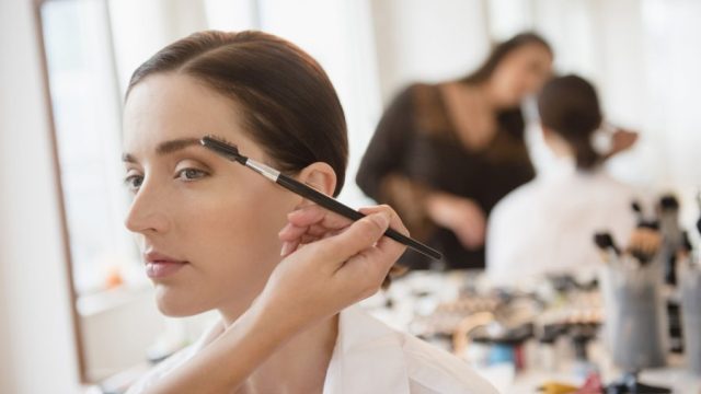eyebrow feathering woman with makeup artist