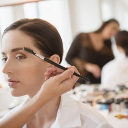 eyebrow feathering woman with makeup artist