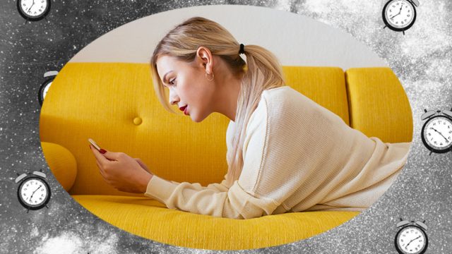 Blonde woman laying on the couch and looking at her phone