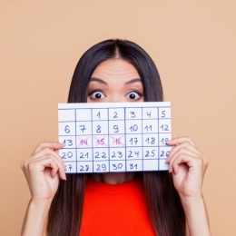 woman holding up calendar period came early