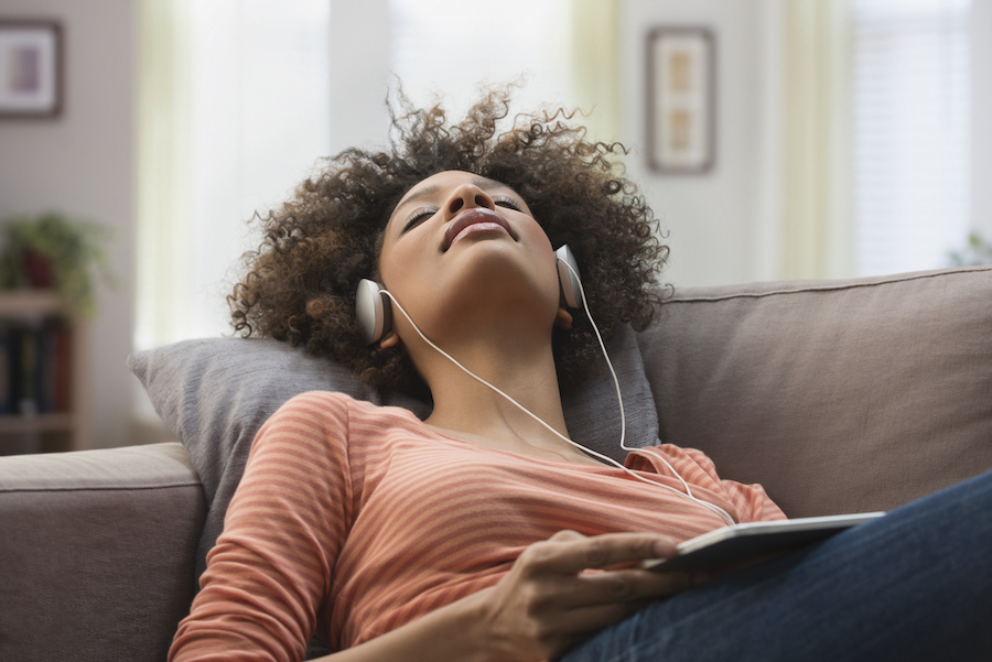 woman-with-headphones-on-couch.jpg