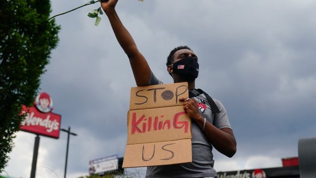 rayshard brooks killed by police officer at wendy's, protestor with sign