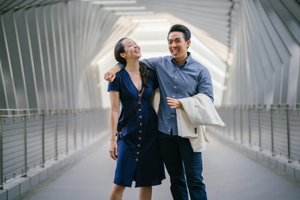 couple laughing on bridge smiling