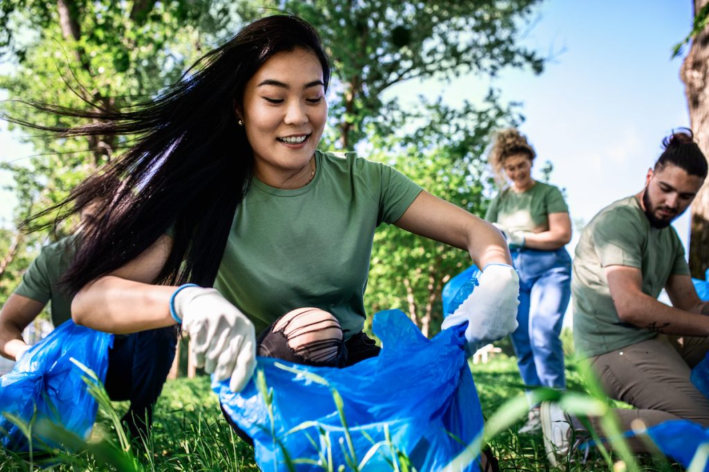 happy woman volunteering cleaning up outside