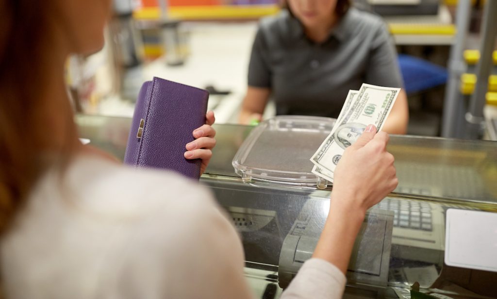 woman paying in cash at register