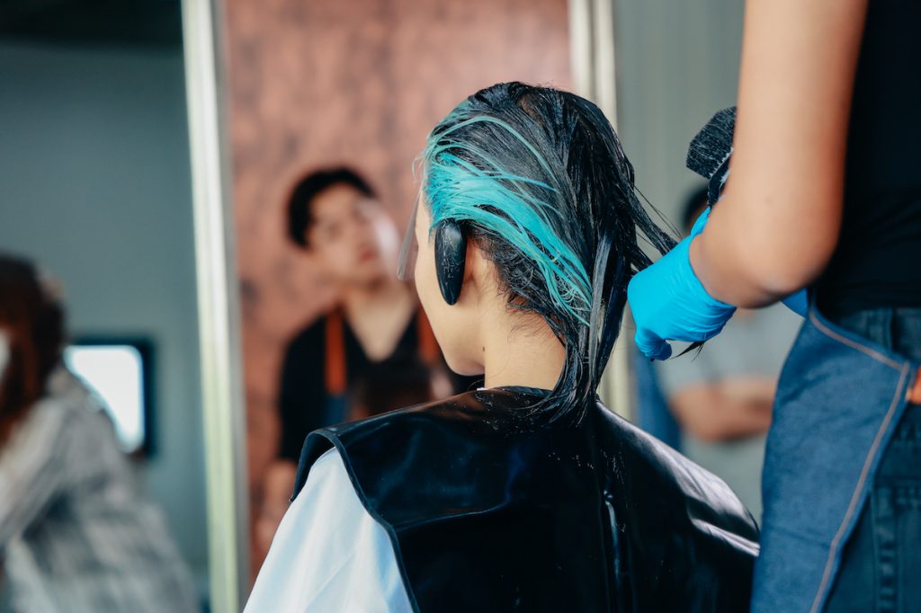 woman getting hair colored blue