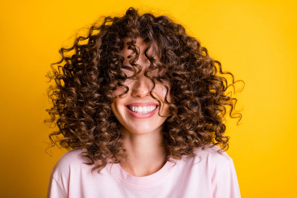 woman with curly hair smiling