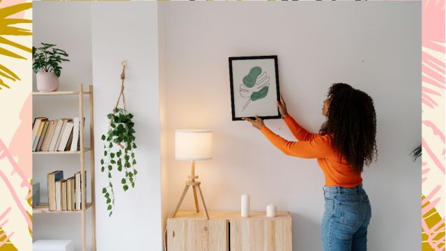 woman hanging picture
