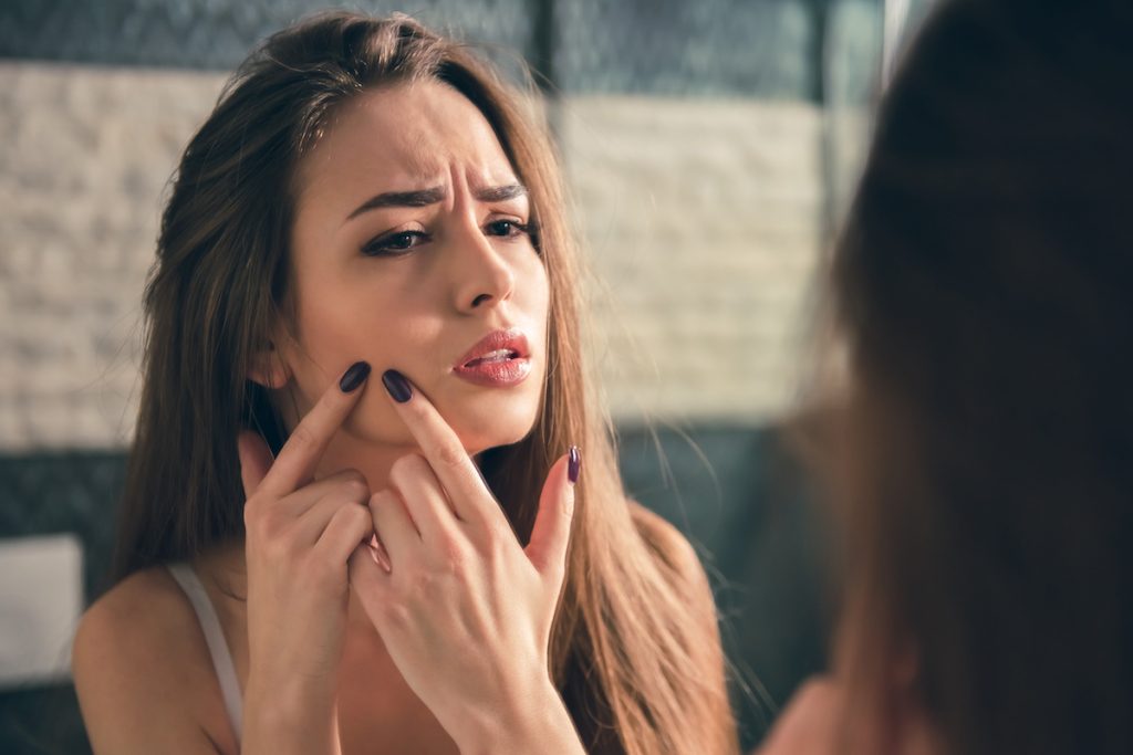 woman popping zit