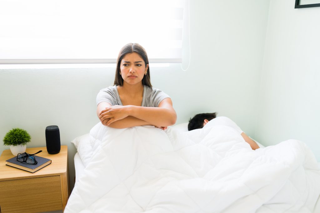 Woman in Bed Next to Partner